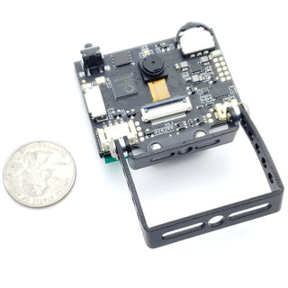 a small camera with a coin next to it